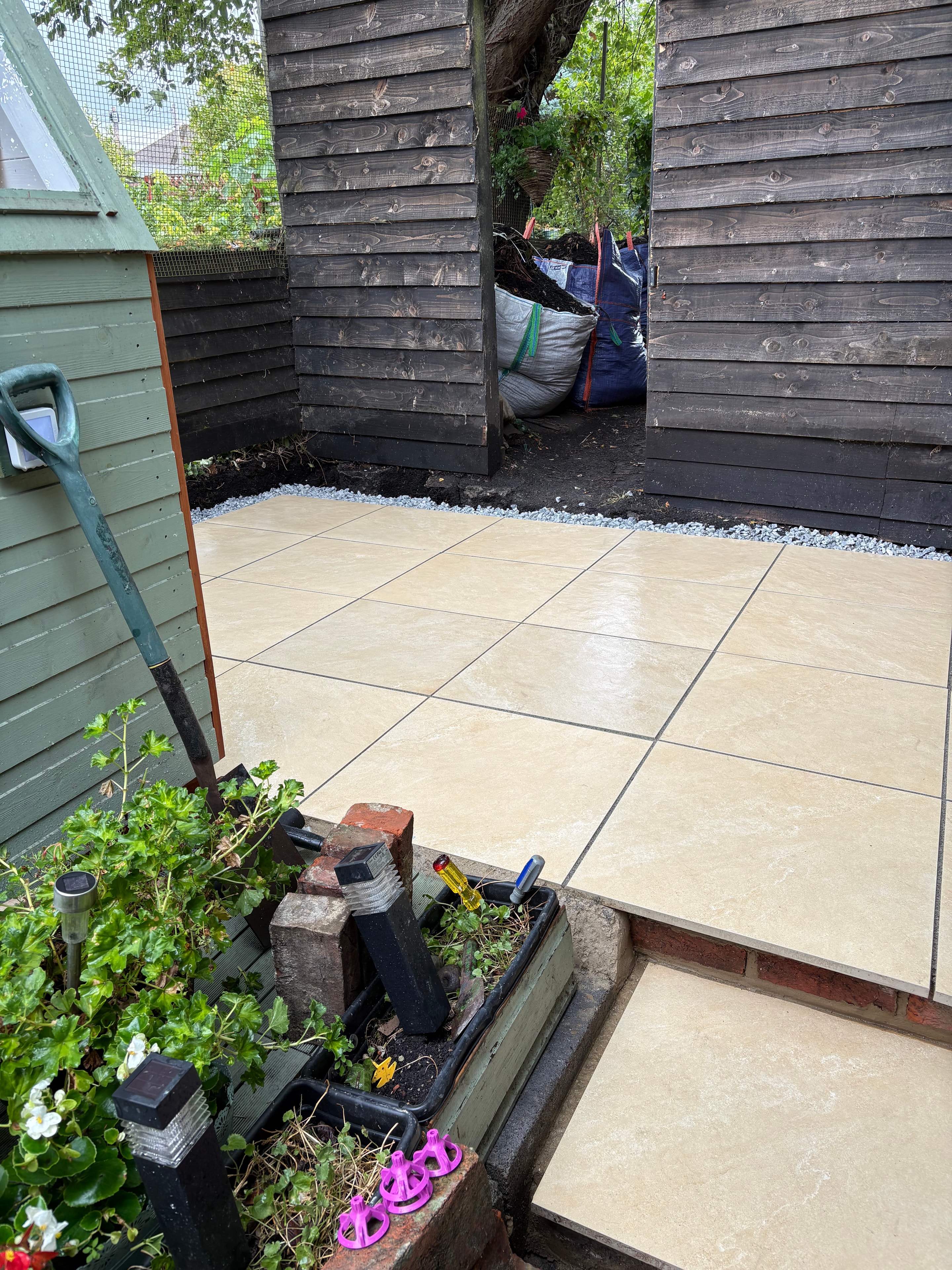 Finished porcelain patio laid by JL & Oak — clean large-format tiles with crisp grout lines